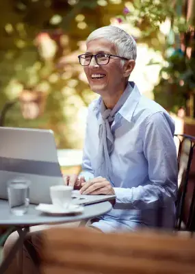 Ellen Degenares Look alike sitting out on a patio with a laptop and smiling for some reason