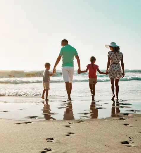 wow, a family walking on a beach. and look at that, one dad, one mom, one boy, and one girl. I wonder where the dog went